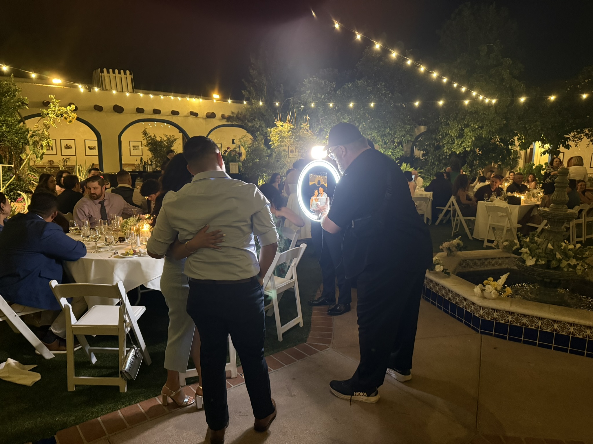 Roaming photographer at outdoor garden event with string lights Tucson
